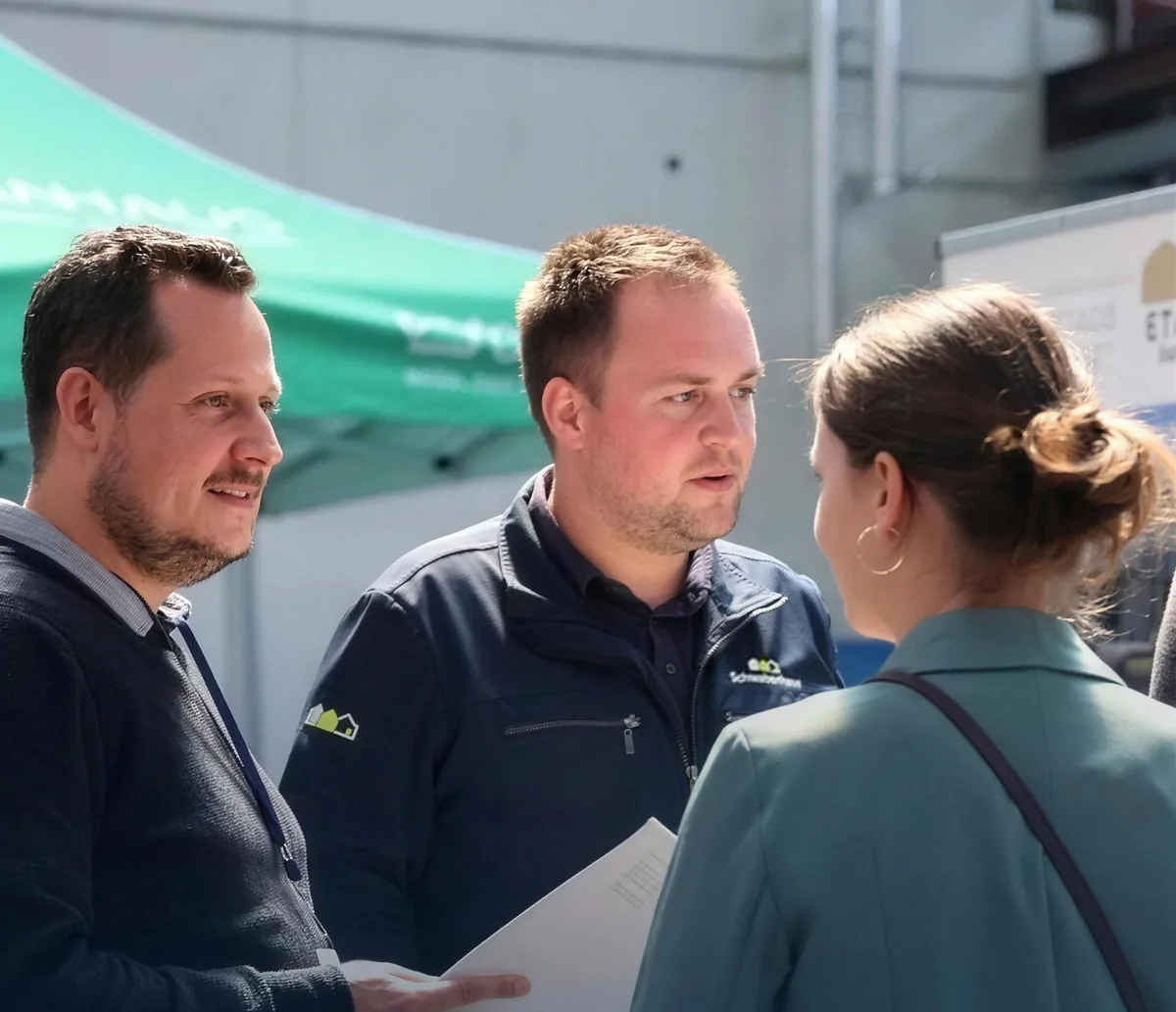 Zwei Schwabenhaus-Berater im Gespräch mit einer Besucherin